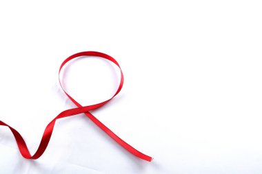 Kırmızı Destek Kurdelesi beyaz arkaplanda izole edildi. Dünya yardımları günü, ulusal HIV / AIDS ve yaşlanma ayını kırmızı kurdeleyle karşılıyor. kopyalama alanı