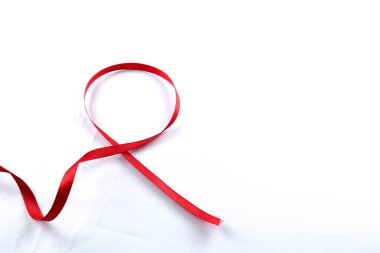 Kırmızı Destek Kurdelesi beyaz arkaplanda izole edildi. Dünya yardımları günü, ulusal HIV / AIDS ve yaşlanma ayını kırmızı kurdeleyle karşılıyor. kopyalama alanı