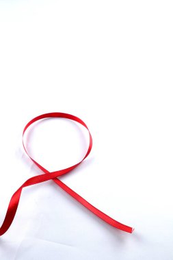 Kırmızı Destek Kurdelesi beyaz arkaplanda izole edildi. Dünya yardımları günü, ulusal HIV / AIDS ve yaşlanma ayını kırmızı kurdeleyle karşılıyor. kopyalama alanı