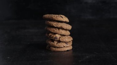 Siyah arka plandaki tahta masada bir yığın çikolatalı kurabiye.