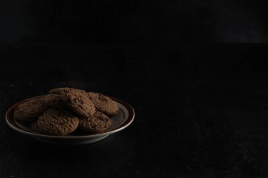 Siyah arka planda çikolata parçalı kurabiyeler