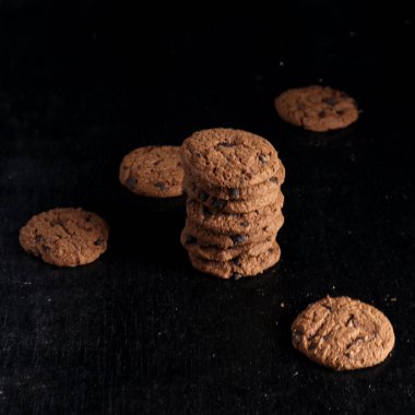 Siyah arkaplanda çikolata parçalı kurabiyeler