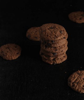 Siyah arkaplanda çikolata parçalı kurabiyeler