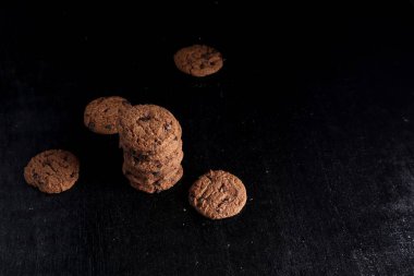 Siyah arkaplanda çikolata parçalı kurabiyeler