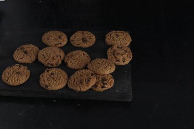 Siyah arkaplanda çikolata parçalı kurabiyeler