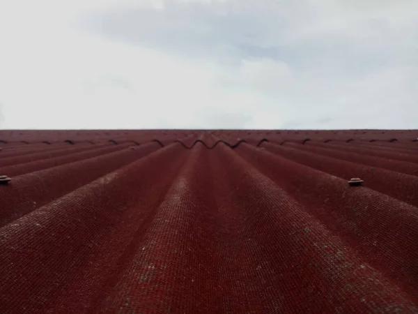 Closeup of red roof cover. Tiled roof with sky background