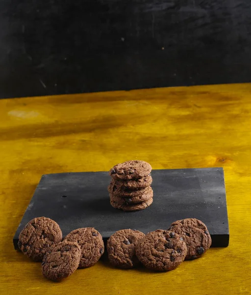 Siyah arkaplanda çikolata parçalı kurabiyeler