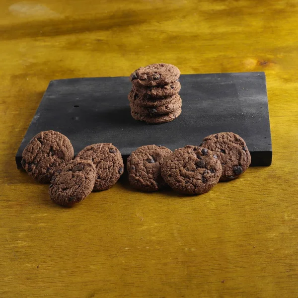 Tahta arka planda çikolata parçalı kurabiyeler