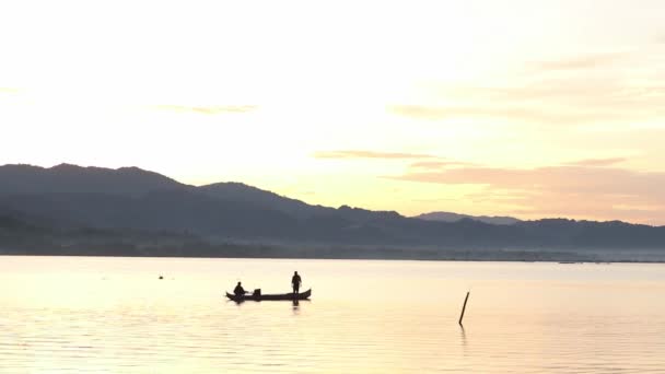 漁船で美しい夕日を楽しみながら釣りをする漁師のシルエット — ストック動画