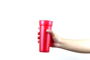Beyaz arka planda kırmızı plastik bardağı tutan el.