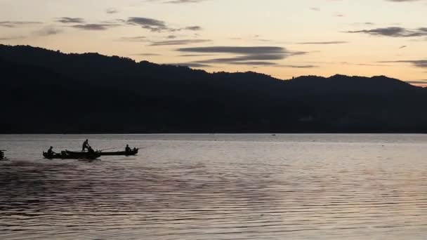 漁船で美しい夕日を楽しみながら釣りをする漁師のシルエット — ストック動画