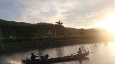 Balıkçıların silueti teknelerinde balık tutarken güzel bir günbatımının keyfini çıkarıyor.