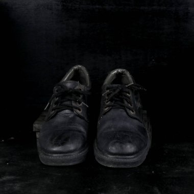 Pair of black male classic shoes on black background. Dusty shoes