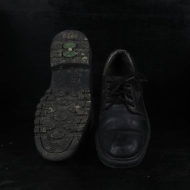 Pair of black male classic shoes on black background. Dusty shoes