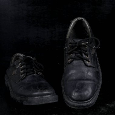 Pair of black male classic shoes on black background. Dusty shoes