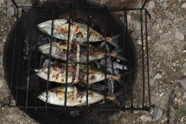 the process of making grilled fish that is burned over coconut shell coals