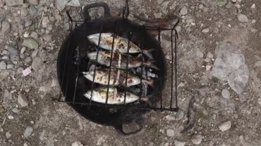 the process of making grilled fish that is burned over coconut shell coals