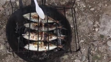 the process of making grilled fish that is burned over coconut shell coals