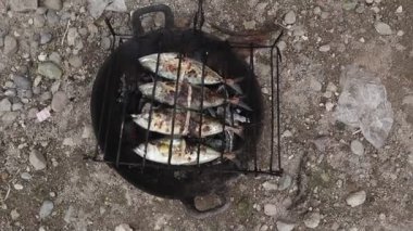 the process of making grilled fish that is burned over coconut shell coals