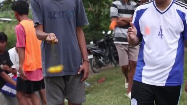 Gorontalo, Indonesia - January 2023 - Teenagers playing Clacker Balls, also known as Latto-Latto in Indonesia. Lato lato