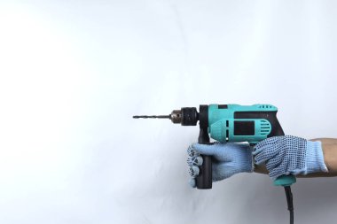 Beyaz arkaplanda izole edilmiş elektrikli matkap tutan eldivenli el.