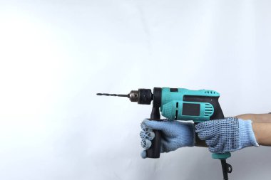 Beyaz arkaplanda izole edilmiş elektrikli matkap tutan eldivenli el.