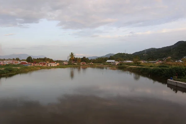 Sebuah Desa Oleh Air Dengan Pegunungan Latar Belakang — Stok Foto