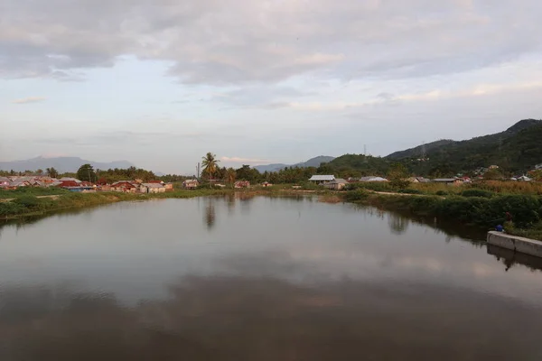 Sebuah Desa Oleh Air Dengan Pegunungan Latar Belakang — Stok Foto