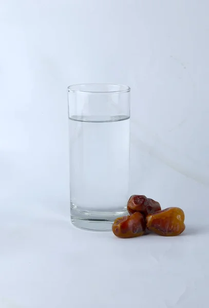 Datteln Und Ein Glas Wasser Isoliert Auf Weißem Hintergrund — Stockfoto
