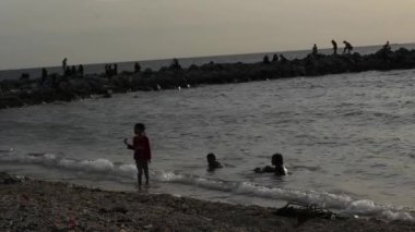 Gorontalo-Endonezya, 2 Mart 2023: Sahilde dalgalara bakan kız