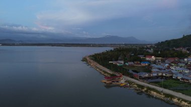 Göl ve dağların yanındaki yolun havadan görünüşü