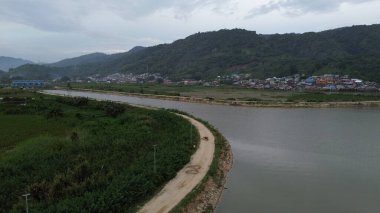 Göl ve dağların yanındaki yolun havadan görünüşü