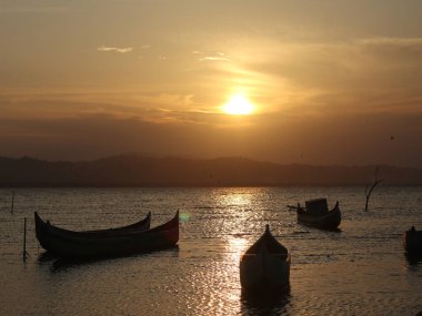 Gün batımında gölde tekne. Limboto Gölü sularında yüzen kayık. Gorontalo, Endonezya