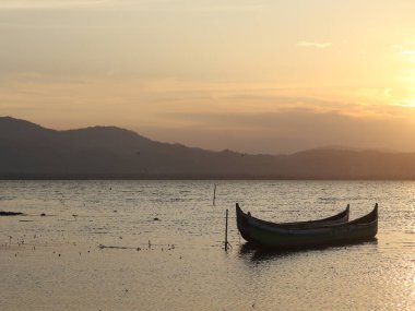 Gün batımında gölde tekne. Limboto Gölü sularında yüzen kayık. Gorontalo, Endonezya