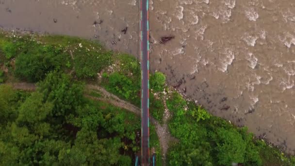 川を渡る吊り下げられた木造の橋の空中眺め — ストック動画