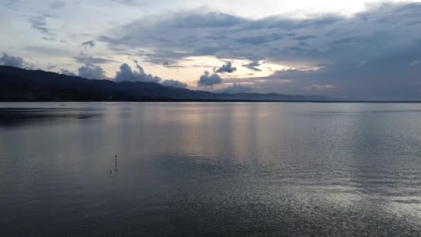 日没の景色と太陽の反射を望む湖の水上空からの眺め 湖の空からの眺め 水の上を飛んでいる 穏やかな湖の表面上のフライト — ストック動画