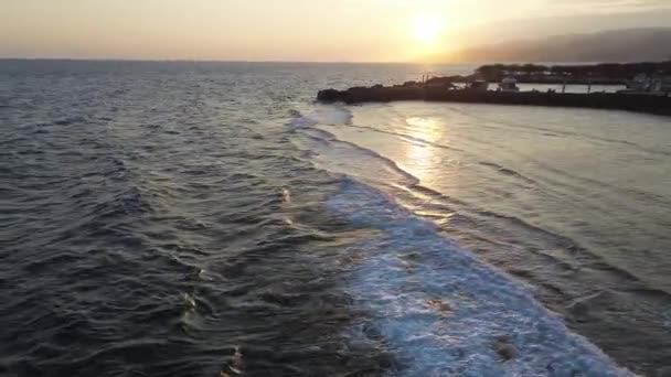 日没時の海の波の空中観測 海の波の上の夕日 砂浜を洗う — ストック動画