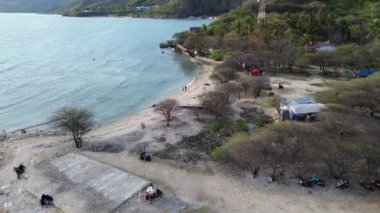 Güneşte yıkanan, yüzen ve kumsalda oyun oynayan insanların havadan görünüşü. Kumsaldaki ve masmavi denizdeki İHA 'nın üst görüntüsü