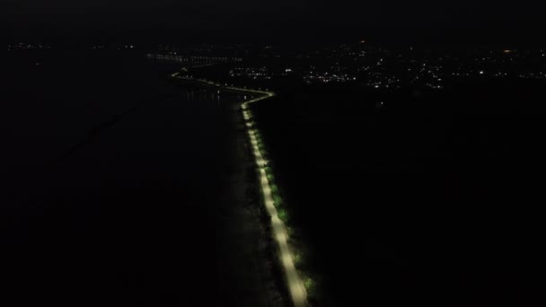 夜間の砂漠化した街並みを眺める ゴロンタロ インドネシア リンボト湖の端にある街灯の連続した眺め — ストック動画