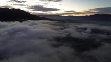 Endonezya 'nın Gorontalo Dağları' ndaki Sabah Güneşinde Bulutların Üzerinde Uçmak. Altın Pofuduk Bulutlar Güneş 'in içinden geçerken usulca gökyüzünde hareket ediyor, Güzel Işıklar saçıyor