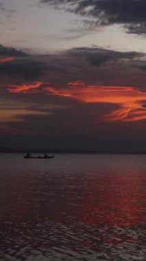 Vertical video of Fisherman Silhouette on His Boat