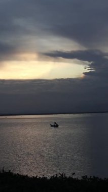 Vertical video of Fisherman Silhouette on His Boat