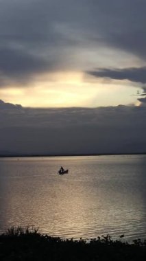 Vertical video of Fisherman Silhouette on His Boat