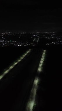 Vertical drone footage of deserted street at night. Vertical video of a row of street lights on the edge of Lake Limboto, Gorontalo-Indonesia