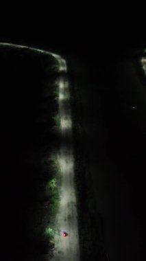 Vertical drone footage of deserted street at night. Vertical video of a row of street lights on the edge of Lake Limboto, Gorontalo-Indonesia