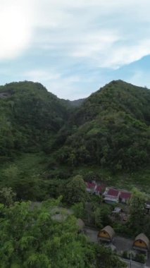 Vertical aerial footage of mountains and valleys against sky. Aerial view of a mountain slope in the afternoon