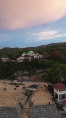 Aerial view of a mosque on the hill in the evening as the sunset