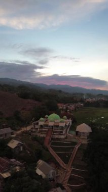 Aerial view of a mosque on the hill in the evening as the sunset