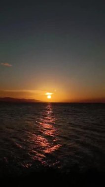 Günbatımında Bulutların Dikey Görüntüsü. Gölde altın gün batımının zamanı geçti.