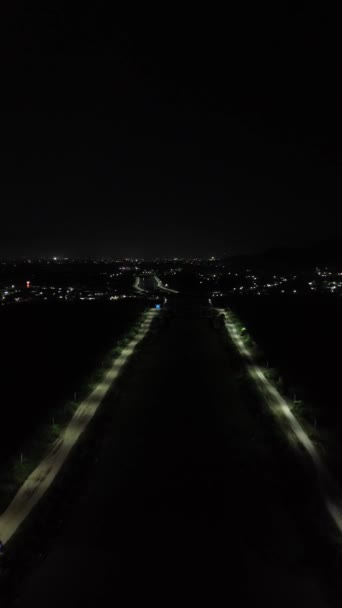 Вертикальный Беспилотный След Дороги Посреди Озера Ночное Время — стоковое видео